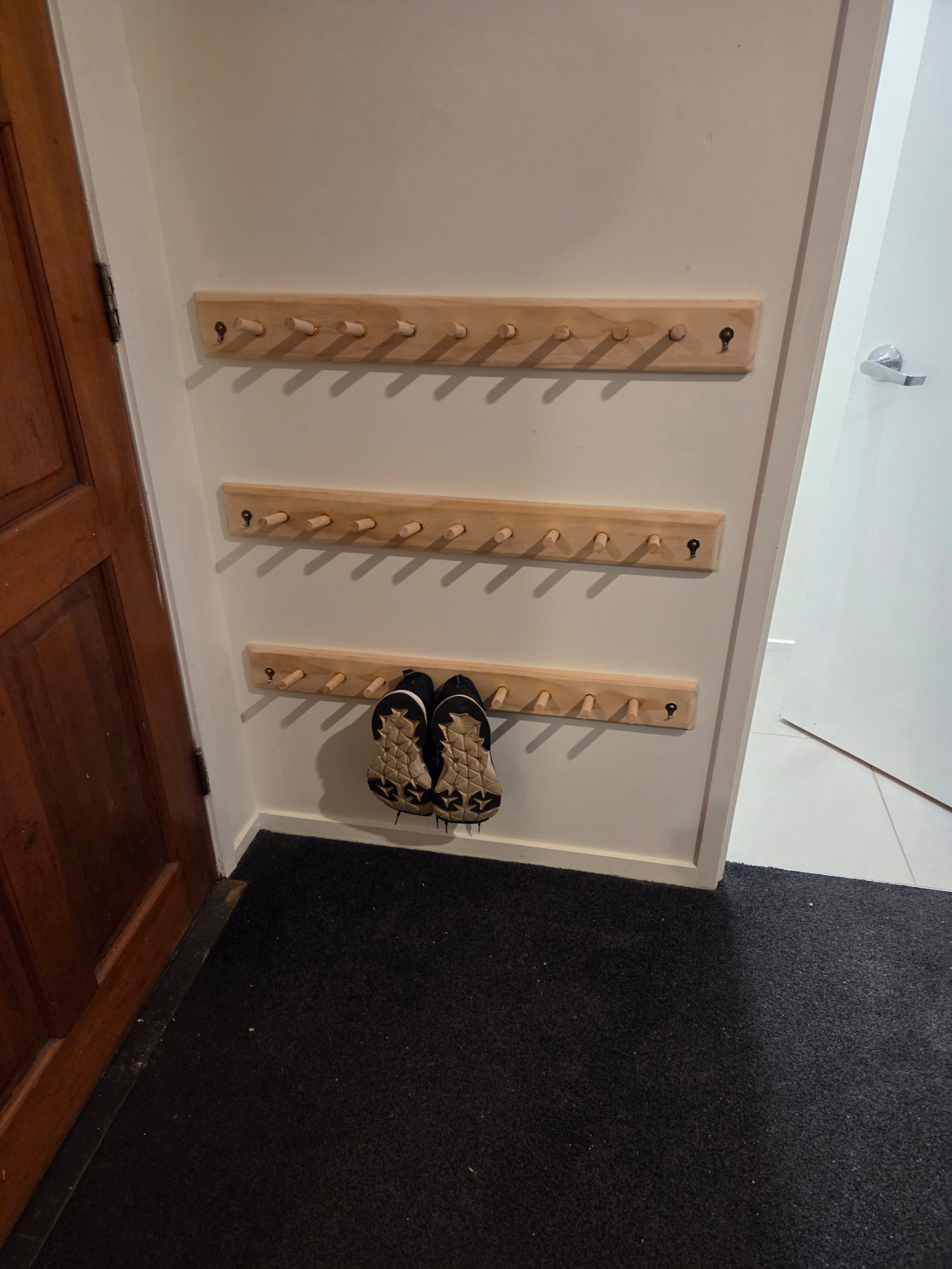 Three timber peg rails fitted in a hallway nook