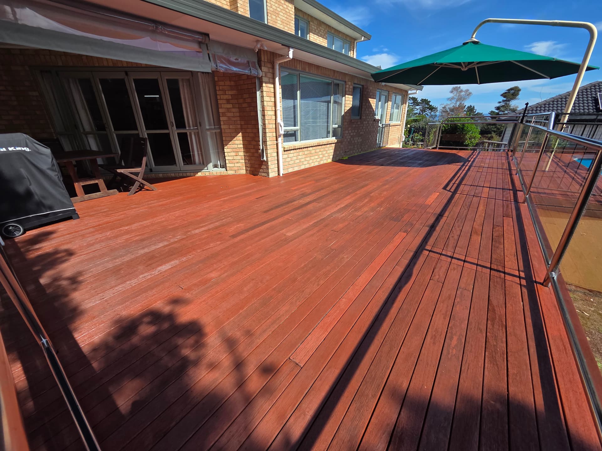 Large poolside deck fully stained a warm red-brown
