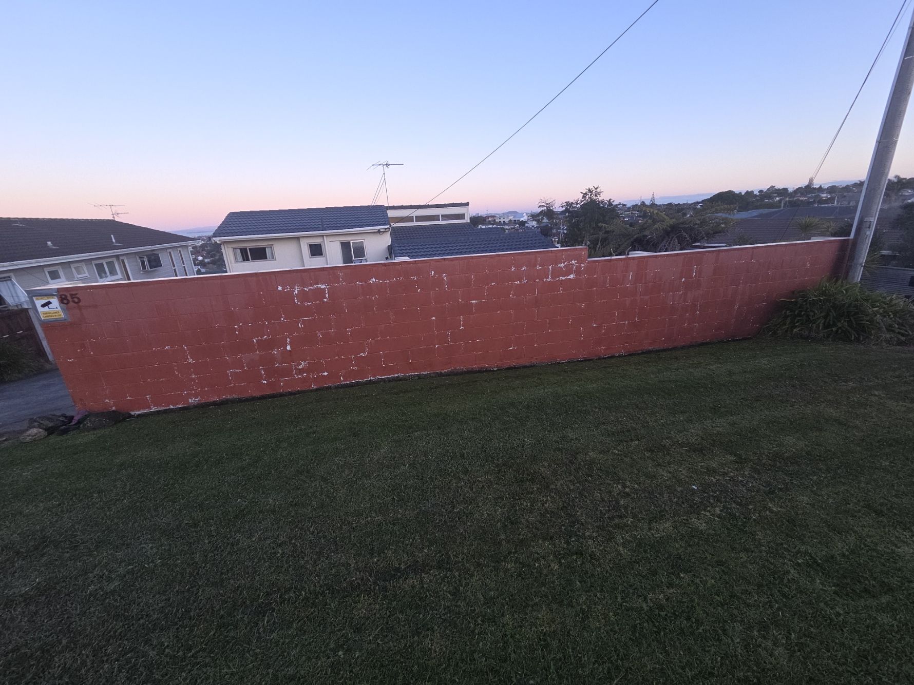 Faded red block boundary wall before repainting